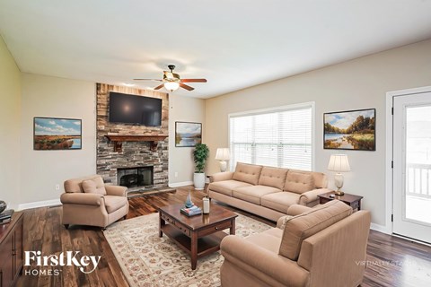 A living room with a fireplace and a tv on the wall.