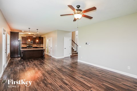 A spacious room with a ceiling fan and wooden flooring.