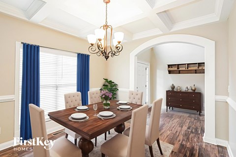 A dining room with a wooden table and chairs.