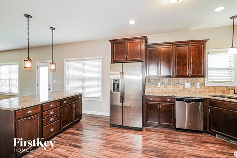 A kitchen with wooden cabinets and a stainless steel refrigerator.