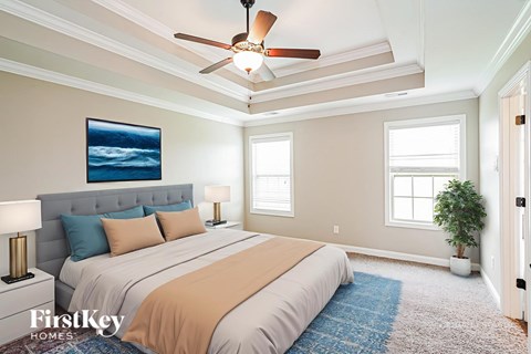 A bedroom with a large bed and a ceiling fan.