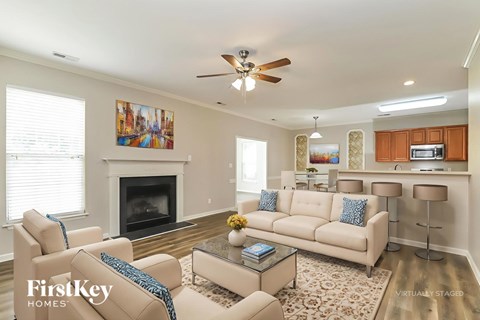 A living room with a fireplace and a painting on the wall.