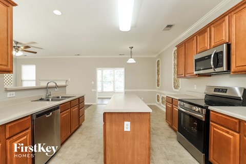 A kitchen with wooden cabinets and a FirstKey Homes logo.