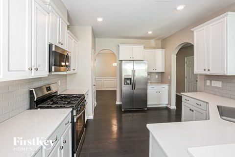 A kitchen with white cabinets and a black stove top.