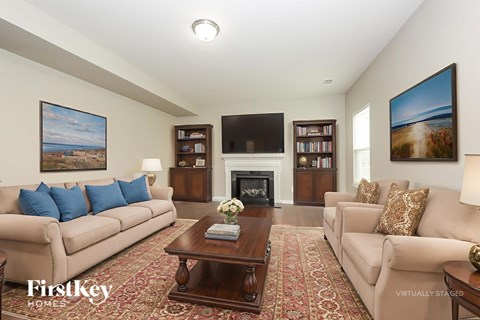A living room with a fireplace and a painting on the wall.