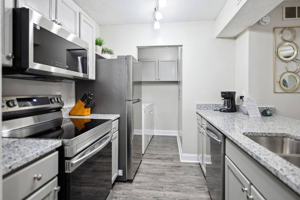 A kitchen with a refrigerator, stove, and microwave.