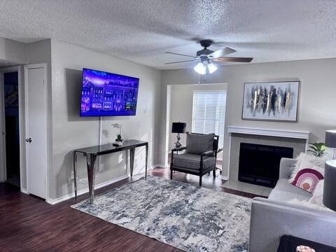 A living room with a flat screen TV mounted on the wall.