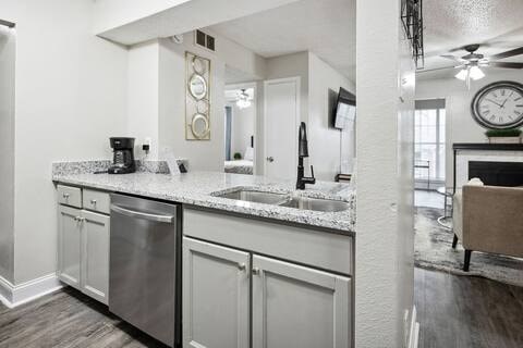 A kitchen with a stainless steel dishwasher and white cabinets.