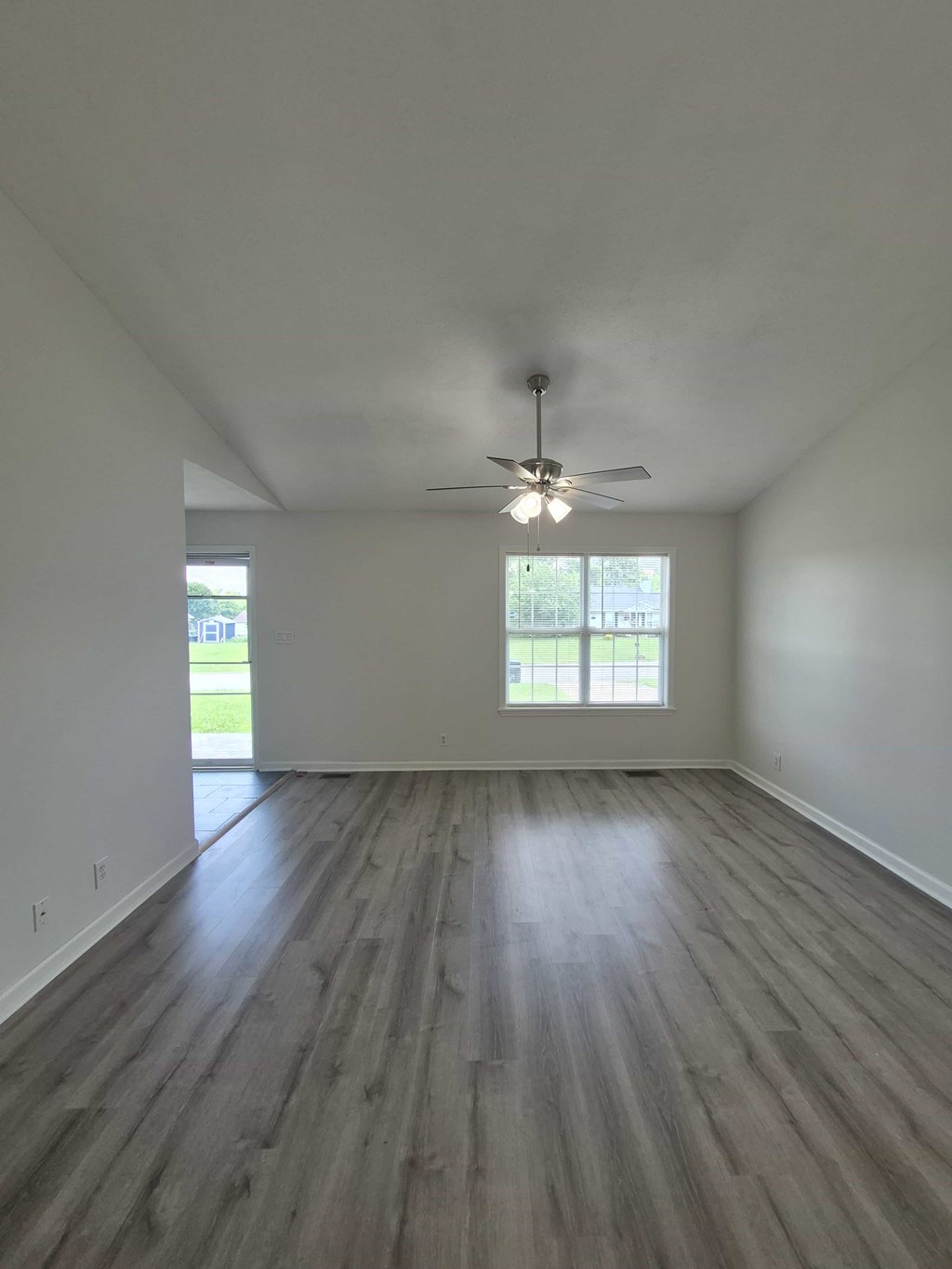 A room with a ceiling fan and a window.