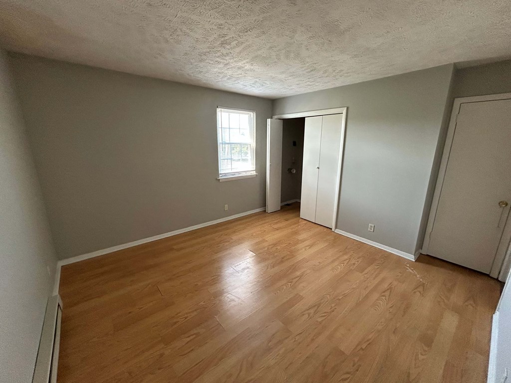 A room with wooden flooring and a window.