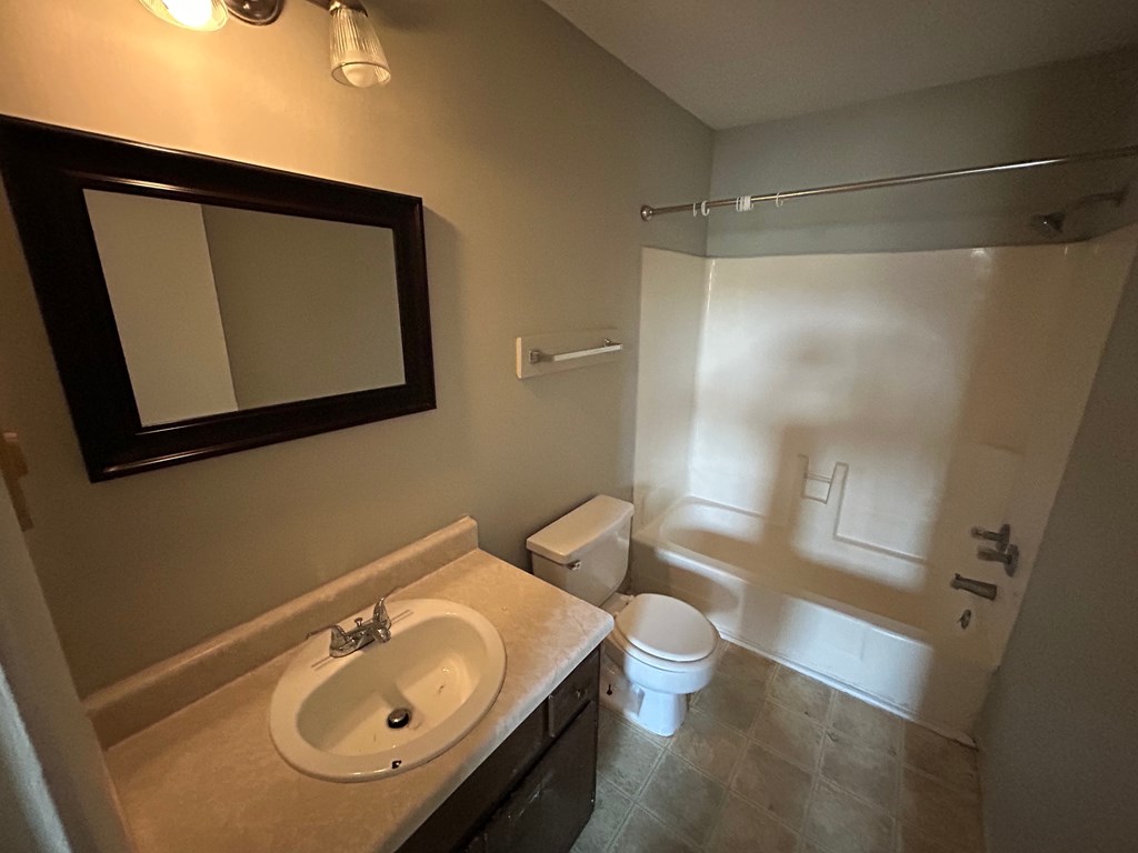 A bathroom with a sink, toilet, and shower.