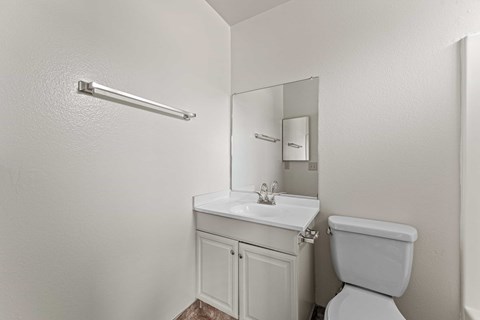 A white toilet sits next to a sink in a small bathroom.