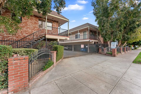 A house with a red brick exterior and a black metal fence.