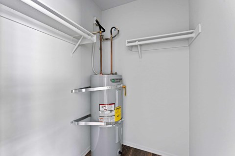 A white wall with a metal pipe and a yellow tag on it.
