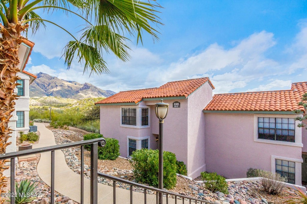 A pink house with a mountain in the background.