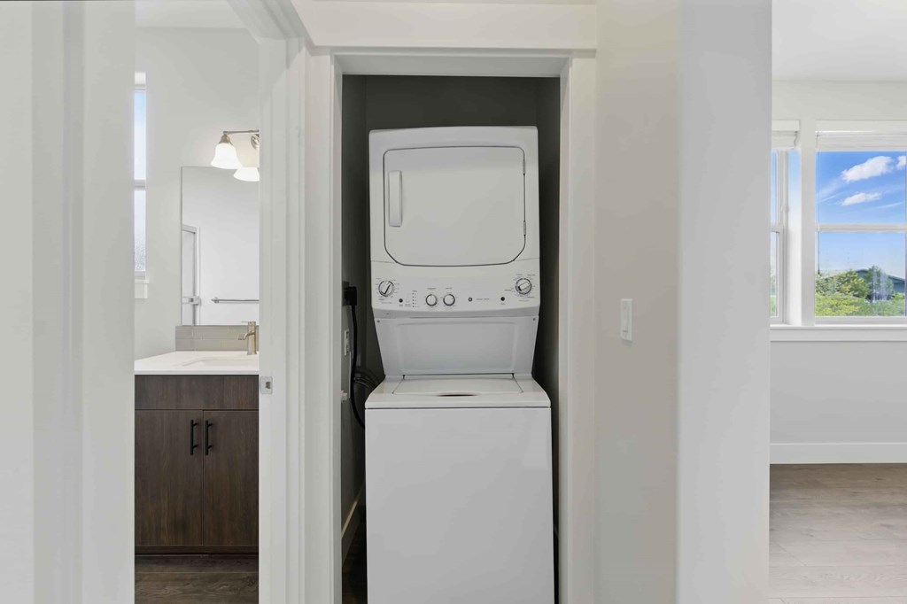 A white washing machine is in a small laundry room.
