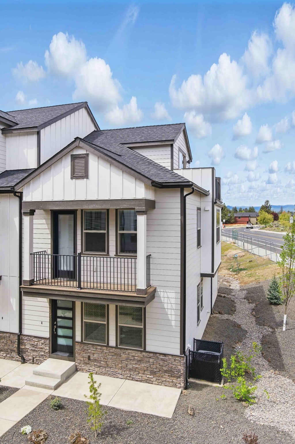A two-story house with a balcony and a green door.