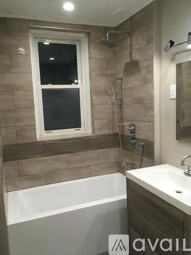 A bathroom with a tub, sink, and window.