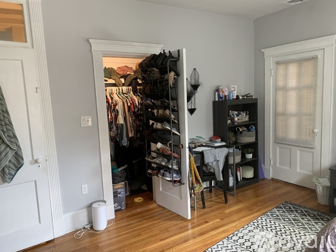 A bedroom with a bed, nightstand, and window.