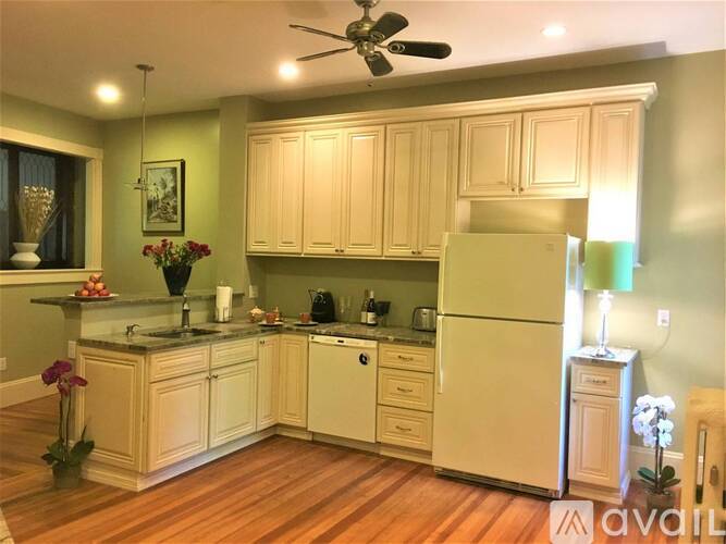 A kitchen with wooden cabinets and a white refrigerator.