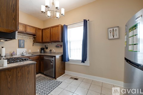 A kitchen with wooden cabinets and a stainless steel refrigerator.