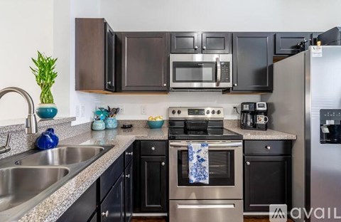 A kitchen with black cabinets and stainless steel appliances.