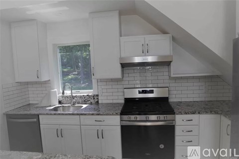 A kitchen with white cabinets and a black stove top oven.