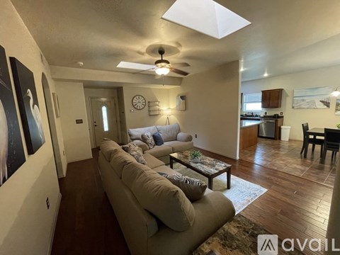 A living room with a long couch and a ceiling fan.