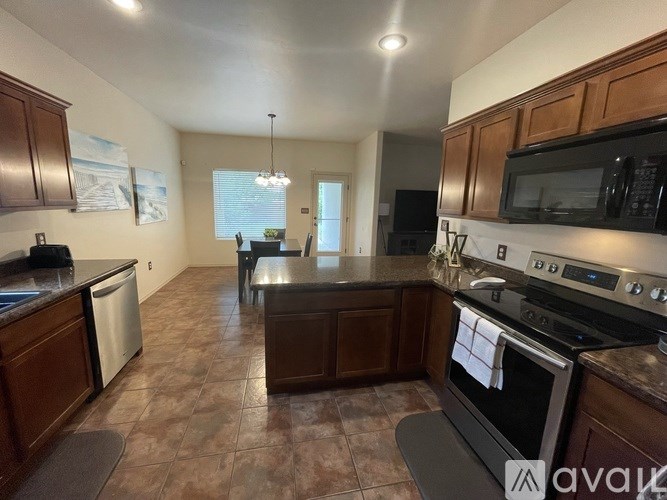 A kitchen with brown cabinets and a black stove top oven.