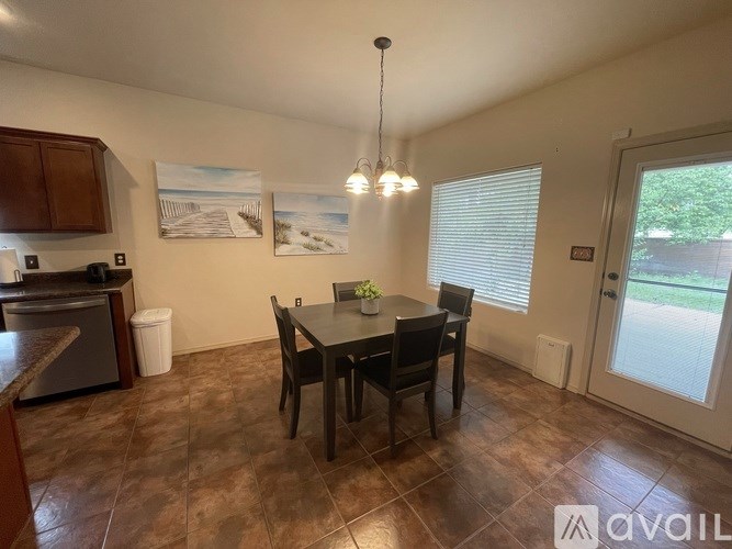 A dining room with a table set for two and a painting on the wall.