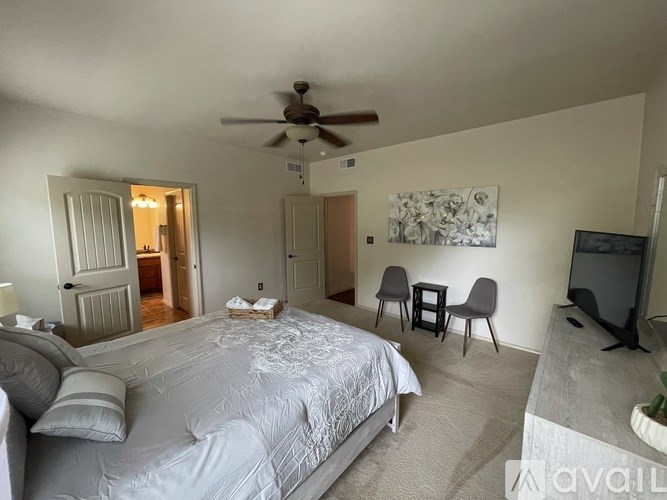 A bedroom with a large bed and a ceiling fan.
