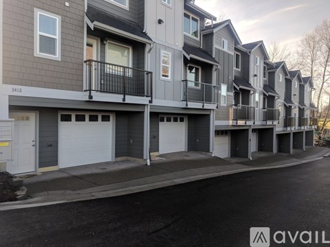 A row of modern townhouses with balconies and garages.