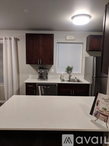 A kitchen with a white countertop and brown cabinets.