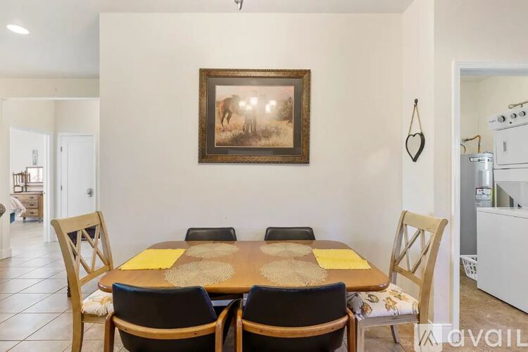 A dining room with a wooden table and chairs.