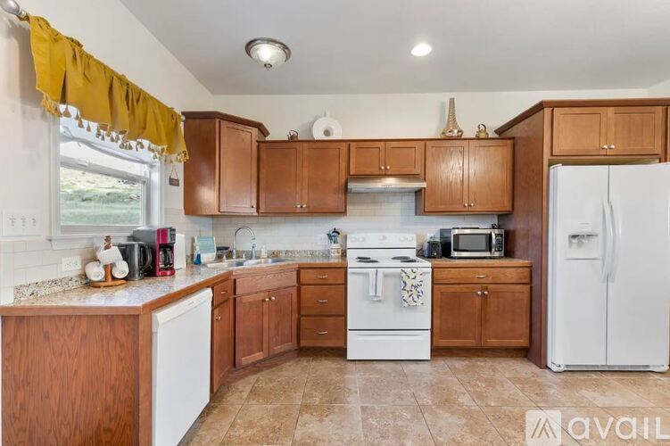 A kitchen with brown cabinets and a white refrigerator.