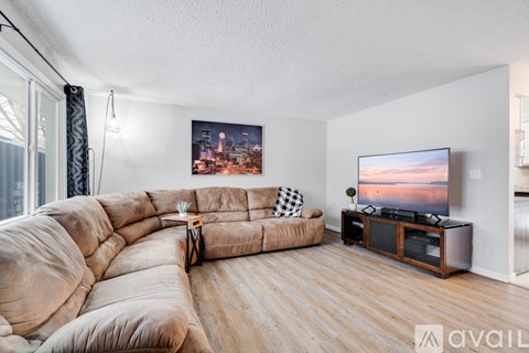 A living room with a large couch and a television on a stand.