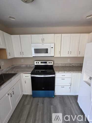 A kitchen with white cabinets and a black stove top oven.