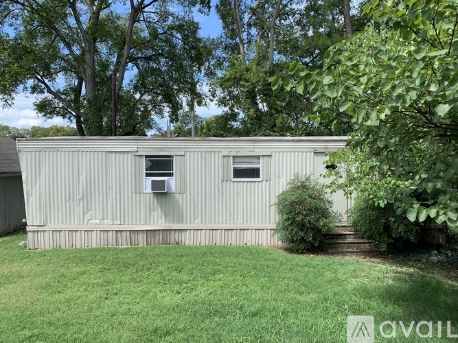 A metal building with a window and air conditioning unit on the side.
