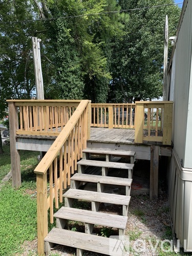 A wooden staircase leads up to a deck.