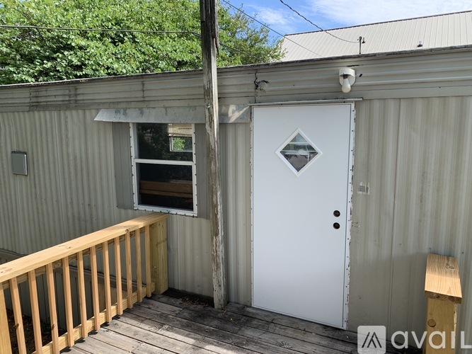A white door with a diamond logo is on a building.