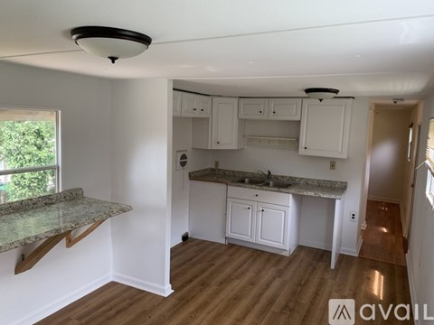 A kitchen with white cabinets and a granite countertop.