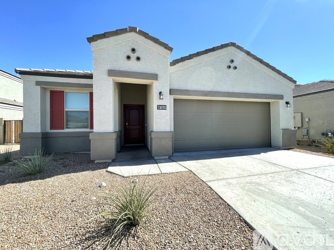 A house with a red door and a garage door.