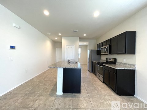 A kitchen with black cabinets and a granite countertop.