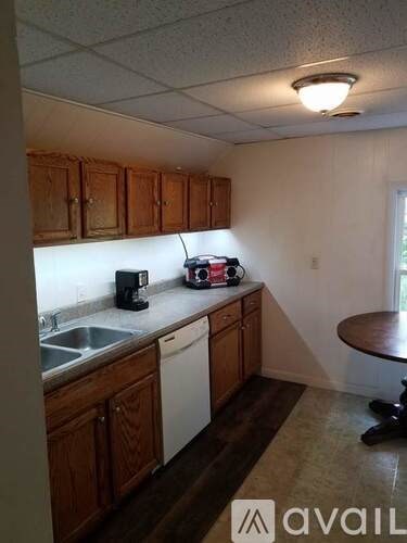 A kitchen with wooden cabinets and a white dishwasher.
