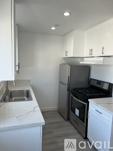A kitchen with a black stove top oven and a white fridge.