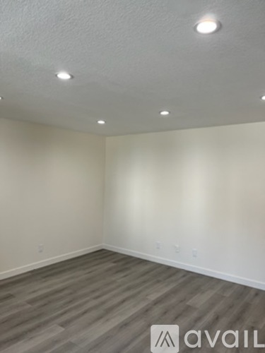 A room with wooden flooring and white walls.