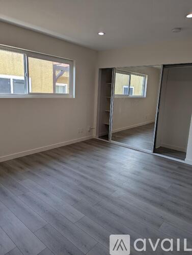 A room with grey flooring and a large window.
