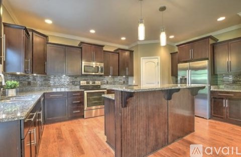 A kitchen with dark wood cabinets and granite countertops.