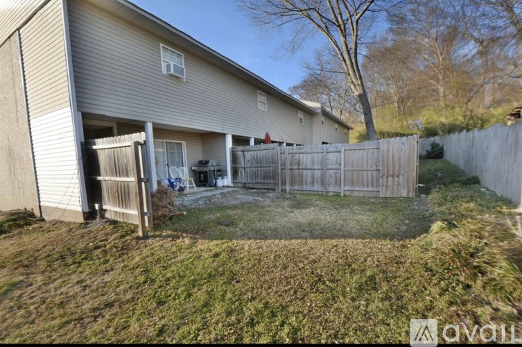 A house with a fenced backyard and a tree.