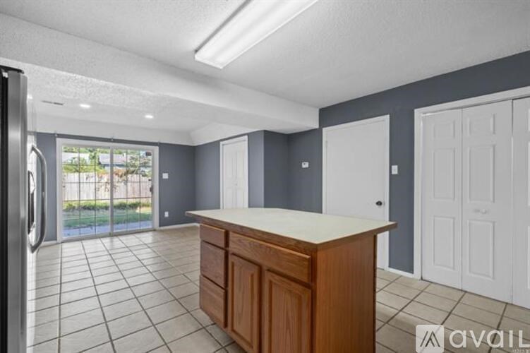 A kitchen with a refrigerator, cabinets, and a countertop is available for rent.